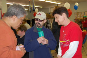 A group of people standing around talking to each other.