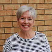 A woman with short hair smiles for the camera.