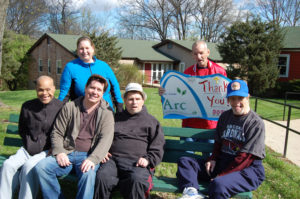 A group of people sitting on top of a bench.