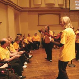 A group of people in yellow shirts and black pants.