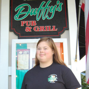 A woman standing in front of a restaurant.