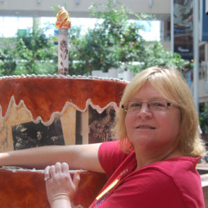 A woman sitting in front of a cake.