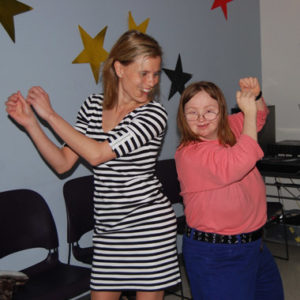 Two women are dancing in a room with stars on the wall.
