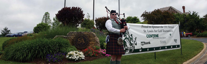 A man in a kilt playing the bagpipes.