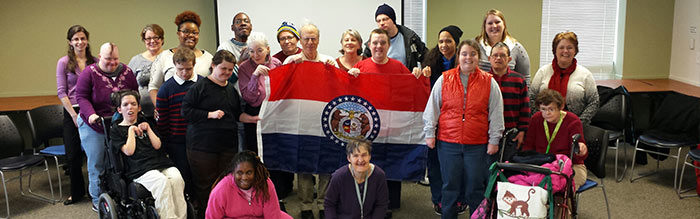 A group of people holding up an american flag.