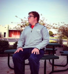 A man sitting on top of a bench.