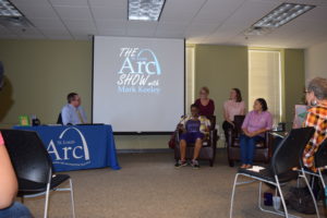A group of people sitting in front of a projector screen.