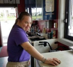 A woman standing in front of a counter.