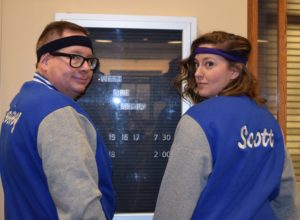 Two people in blue jackets and purple headbands
