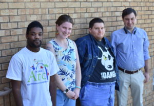 A group of people standing in front of a brick wall.
