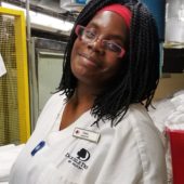 A woman in white shirt and red glasses.