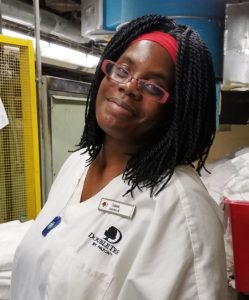 A woman in white shirt and red glasses.