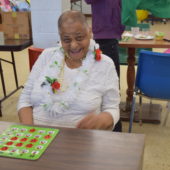 A woman sitting at a table with a game board.