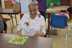 A woman sitting at a table with a game board.