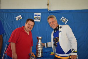 Two men standing next to a trophy.