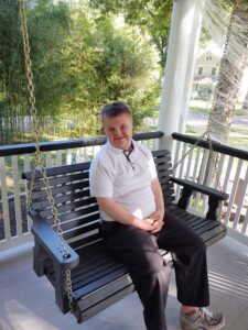 A man sitting on top of a wooden bench.