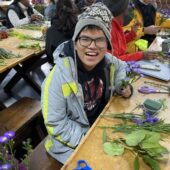 Camper doing crafts and smiling for the camera