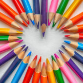 Colored pencils laid out to make a heart shape