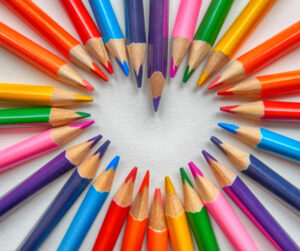 Colored pencils laid out to make a heart shape
