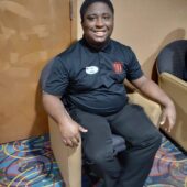 A young man sits in a chair at work